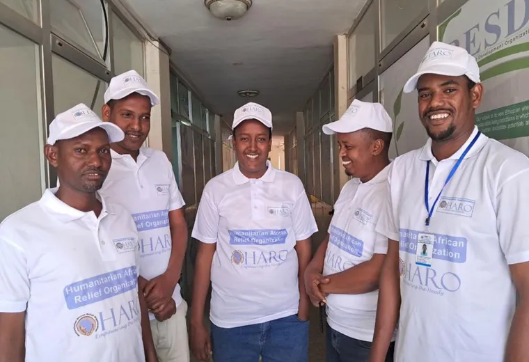 Five members of the HARO team in HARO caps and shirts