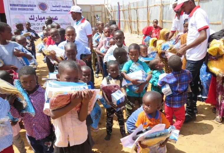 Children hold gift parcels at a HARO Eid distribution for orphans