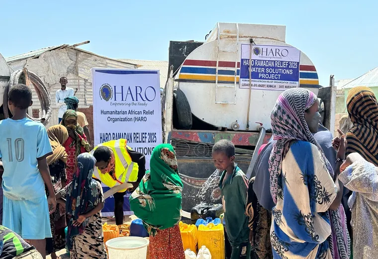 A HARO worker fills jerrycans from a water tanker during Ramadan relief, 2025