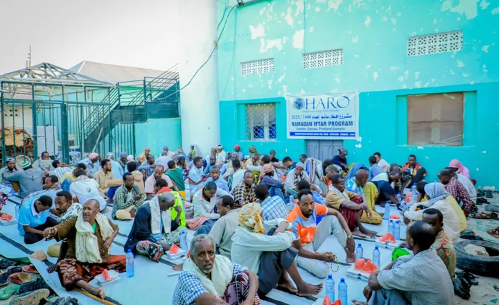 Men seated for iftar beneath the HARO Ramadan Iftar Program banner in Garowe, 2025