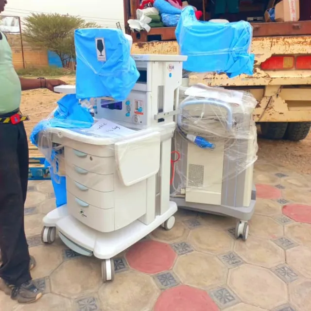 An anesthesia machine and equipment wrapped in plastic beside a delivery truck