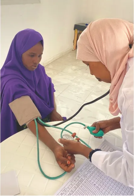 A health worker checks a woman's blood pressure at a HARO-supported clinic
