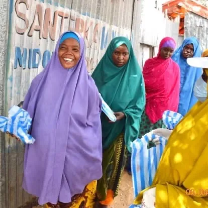 Women hold packs of face masks from a HARO distribution, 2020