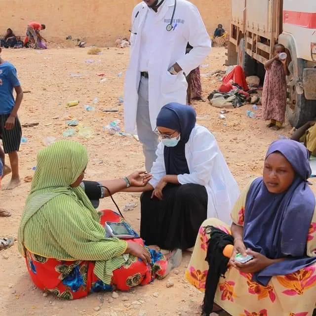 A health worker checks a woman's blood pressure during a HARO field medical visit
