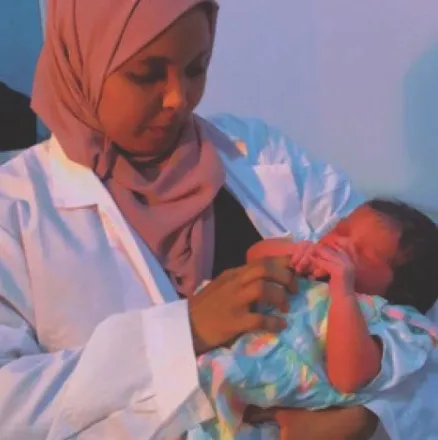 A nurse cradles a newborn at a HARO-supported health facility