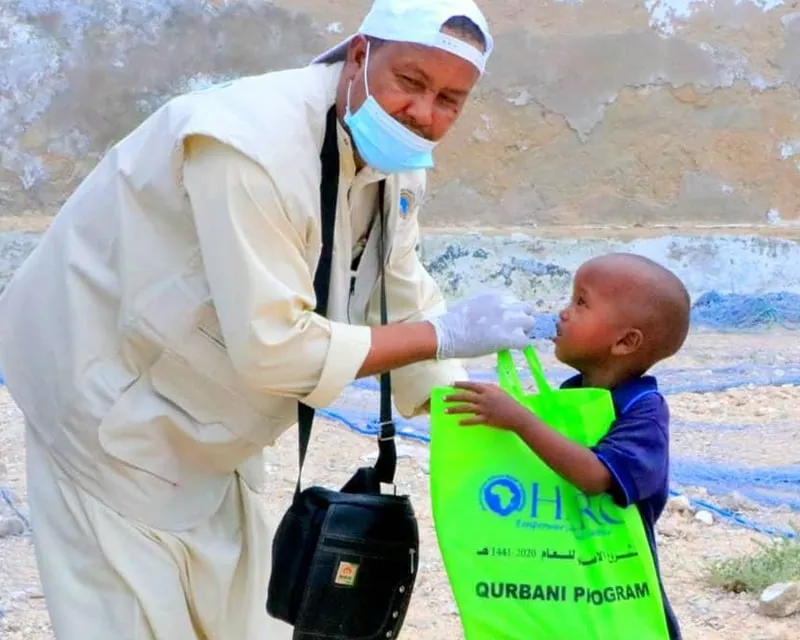 A HARO field worker with a child during a healthcare outreach visit