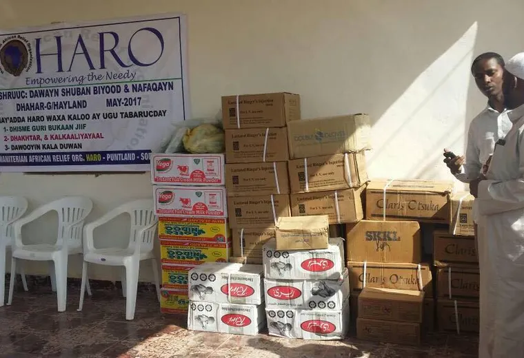 Boxes of donated medicines and IV fluids beside the HARO project banner at Dhahar Hospital, 2017