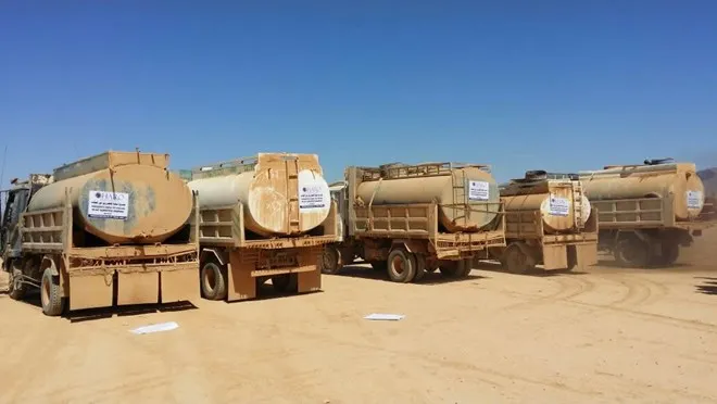 A fleet of HARO-hired water tanker trucks lined up in the desert during the Sool drought response, 2017