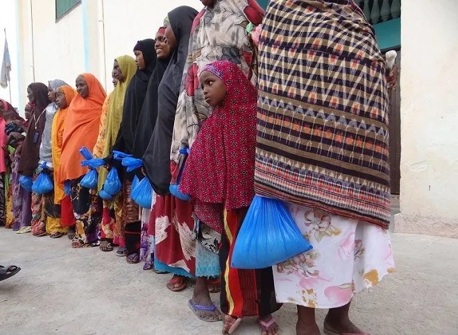 Women and girls holding bags of food from the Zakat al-Fitr distribution in Wadajir, Mogadishu, 2014