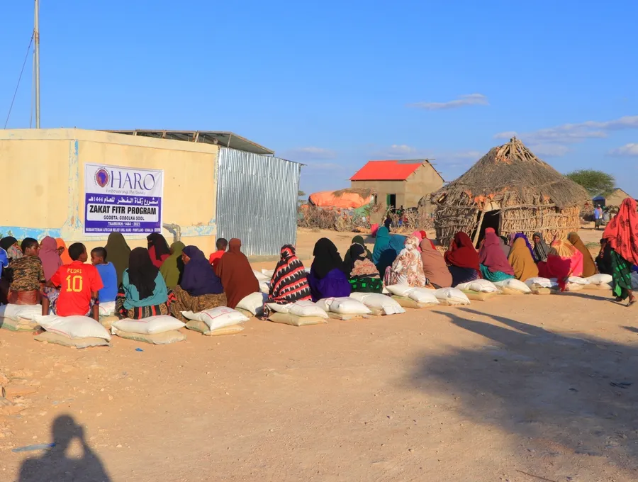 Families seated with sacks of food at the HARO Zakat al-Fitr distribution in Sool region, 2023